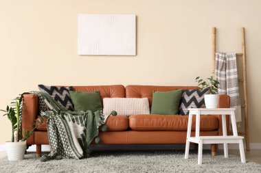 Oturma odasının iç tarafında rahat bir kanepe ve bitkiler var.