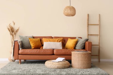 Rahat bir kanepe, kahve masası ve pouf oturma odasının içinde.