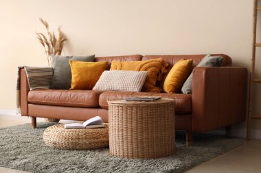 Rahat bir kanepe, kahve masası ve pouf oturma odasının içinde.