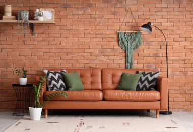 Modern oturma odasının içinde rahat bir kanepe, çiçek ve lamba.