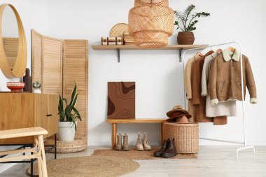 Koridorun içinde ahşap bank, katlanır ekran ve askılık var.