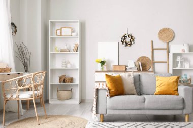 Paskalya için dekore edilmiş oturma odasının içinde kanepe, raf ünitesi ve çelenk var.