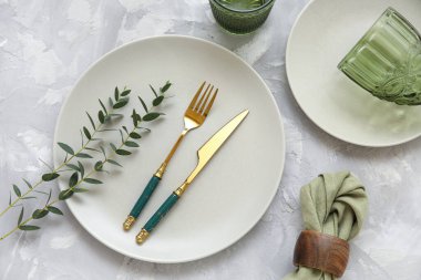 Gri arkaplanda okaliptüs dalları olan güzel masa ayarları