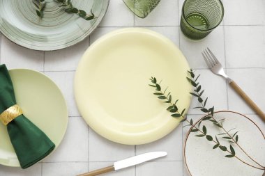 Beyaz fayans zemininde okaliptüs dalları olan güzel masa ayarları