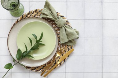 Beyaz seramik zemin üzerinde taze yeşil yapraklar ile güzel masa ayarları