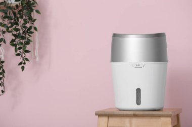 Pembe duvarın yanındaki masada hava nemlendirici var. Yakın plan.