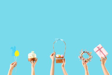 Paskalya dekorlu kadın elleri ve mavi arka planda hediye.