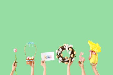 Yeşil arka planda Paskalya dekoru olan kadın elleri