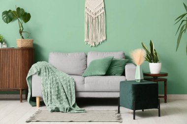 Kanepe ve yeşil pouf ile oturma odasının içinde.