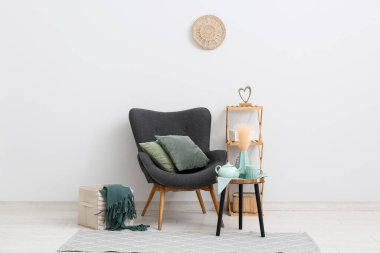 Oturma odasının içinde koltuk, nane çayı ve bardak var.