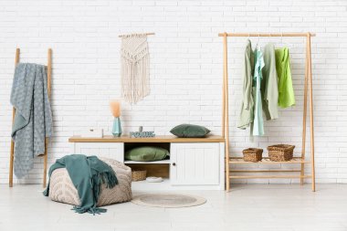 Elbise askısı, bank ve puf olan soyunma odasının içinde.