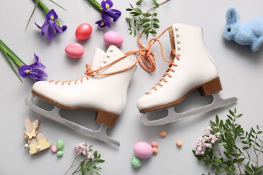 Buz patenli kompozisyon, paskalya yumurtaları ve gri arka planda çiçekler