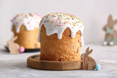 Tatlı Paskalya pastalı ahşap tabak ve gri masadaki tavşan.