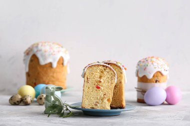 Gri masadaki boyalı yumurtalı ve oyuncak tavşanlı Paskalya pastaları