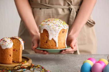 Paskalya pastalı ve beyaz arka planda yumurta boyalı kadın, yakın plan.
