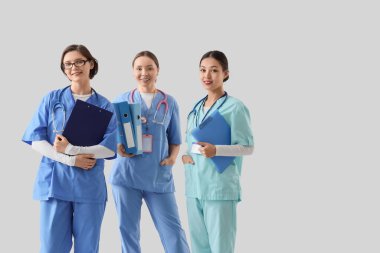 Arkaplanı aydınlık olan dosya ve dosyalarla dolu kadın doktorlar. Uluslararası Hemşireler Günü