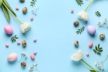 Paskalya yumurtalarından, yeşil yapraklardan ve mavi arka planda çiçeklerden yapılmış çerçeve