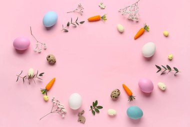 Paskalya yumurtaları, çiçekler ve pembe arka planda dekoratif havuçlardan yapılmış çerçeveler.