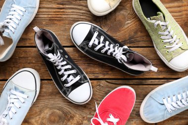 Ahşap arka planda farklı spor ayakkabılar. Üst görünüm