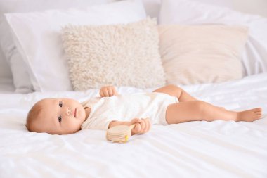 Evde, yatakta çıngıraklı şirin bir bebek yatıyor.