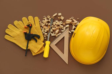 Marangoz aletleri, kep ve ahşap talaşı kahverengi arka planda.
