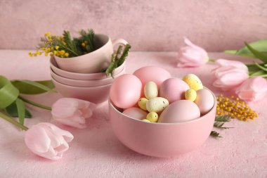 Çiçekli kompozisyon, paskalya yumurtası ve kase pembe grunge arka planda, yakın plan.