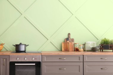 Tezgahında elektrikli soba ve fırın olan modern mutfağın iç mimarisi.