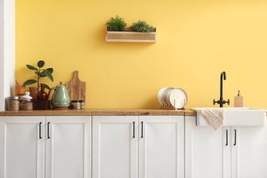 Modern mutfağın içinde mutfak tezgahları, mutfak aletleri ve lavaboları var.