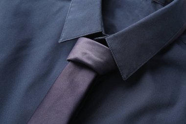 Yakından bakınca, şık mavi yakalı gömlek ve kravat.