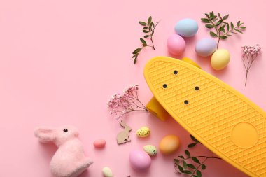 Kaykaylı kompozisyon, pembe arka planda Paskalya yumurtası ve dekor.