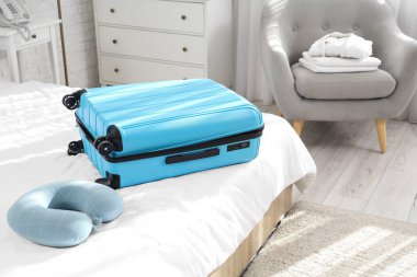 Otel odasında yastıklı bavul.