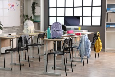 Sıraları ve sırt çantaları olan modern sınıfın içi