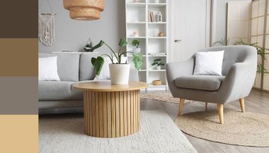 Aydınlık oturma odasının içinde gri kanepe, koltuk ve bitkilerle dolu bir masa. Farklı renk desenleri