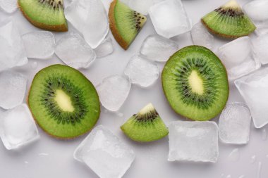 Gri arkaplanda taze kivi ve buz dilimlenmiş.