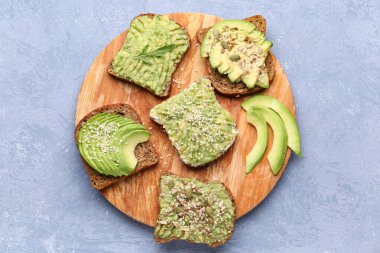 Gri arka planda lezzetli avokado tostları.