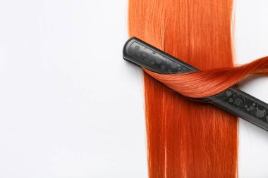 Beyaz arka planda düz demiri olan kızıl saçlı, yakın plan.