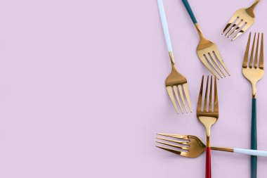 Pembe arka planda altın çatallar