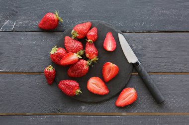 Siyah ahşap zemin üzerinde taze çilek olan tahta.