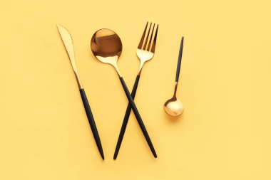 Sarı arkaplanda şık çatal bıçak takımı
