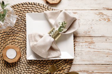 Mum ve çigila çiçekli güzel masa ayarları açık ahşap arka planda