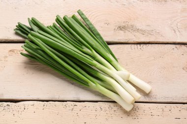 Beyaz ahşap zemin üzerinde taze yeşil soğan