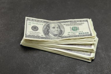 Siyah grunge arka planında 100 dolarlık banknot yığını