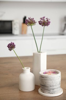 Mutfaktaki masada güzel çiçekler ve mum, yakın plan.