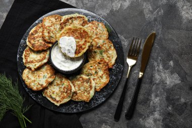 Koyu arkaplanda ekşi kremalı lezzetli kabaklı börek.