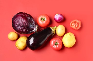 Kırmızı arka planda farklı taze sebzeler