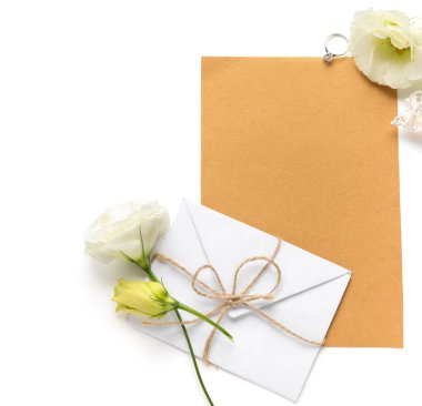 İçinde boş kart, zarf, nişan yüzüğü ve beyaz arka planda güzel Eustoma çiçekleri olan kompozisyon