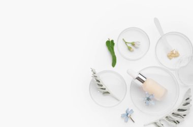 Beyaz arka planda numune, bitki ve bir şişe kozmetik ürünü içeren petri kapları