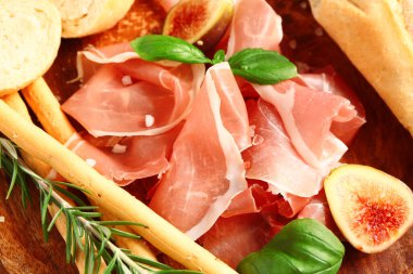 Lezzetli jambon, fesleğen, İtalyan Grissini ve incir dilimleri, yakın plan.