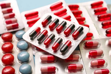 Mavi arka planda farklı haplar içeren kabarcık paketleri