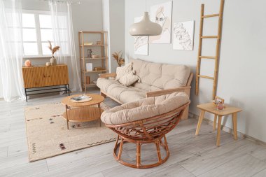 Tabloları, kanepesi ve koltuğu olan şık bir oturma odası.